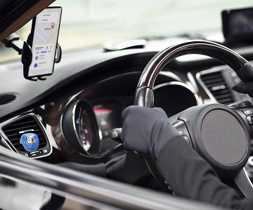 A hand in the black leather glove holds a wheel.